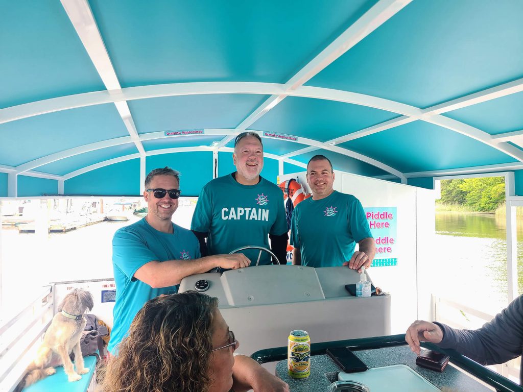 Three smiling captains on cycle boat